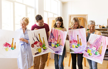 Image showing group of artists with pictures at art school