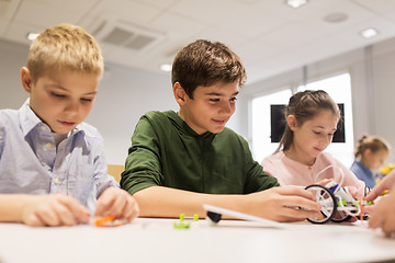 Image showing happy children building robots at robotics school