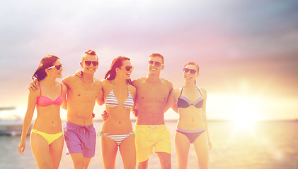 Image showing smiling friends in sunglasses on summer beach