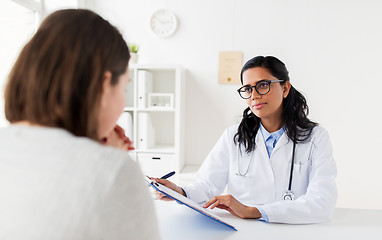 Image showing doctor with clipboard and woman patient at clinic