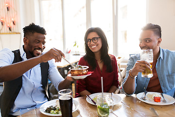 Image showing happy friends eating at restaurant