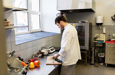 Image showing happy male chef cooking food at restaurant kitchen