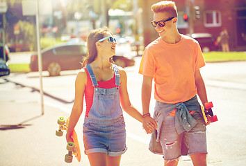 Image showing teenage couple with skateboards on city street