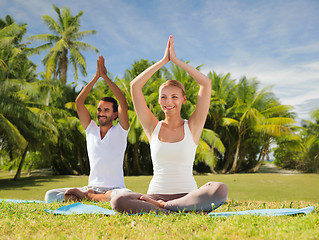 Image showing couple doing yoga in lotus pose outdoors