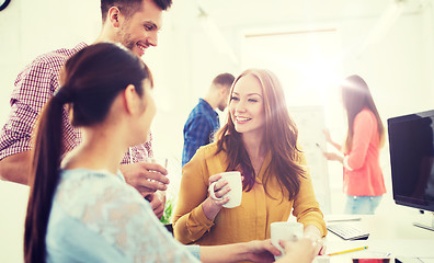 Image showing happy creative team drinking coffee at office