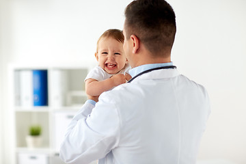 Image showing happy doctor or pediatrician with baby at clinic