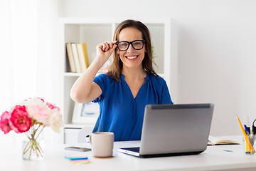 Image showing happy woman with laptop working at home or office