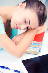 Image showing tired student sleeping on stock of books