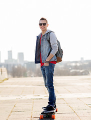 Image showing happy young man or teenage boy riding on longboard