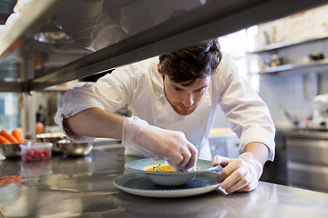 Image showing happy male chef cooking food at restaurant kitchen