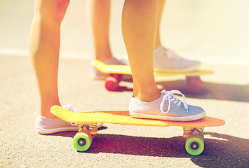 Image showing close up of female feet riding short skateboard