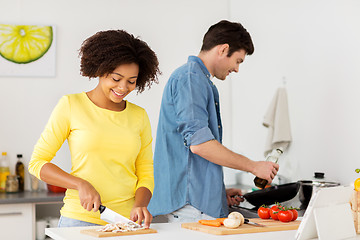 Image showing happy couple cooking food at home kitchen