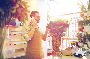 Image showing man with smartphone and red roses at flower shop