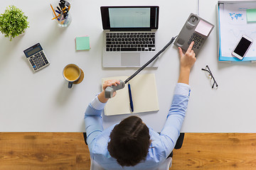 Image showing businesswoman calling on phone at office table