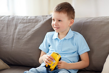 Image showing happy little boy with toy car at home