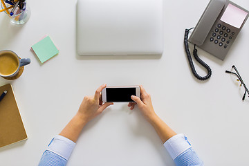 Image showing businesswoman with smartphone working at office