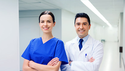 Image showing smiling doctor in white coat and nurse at hospital