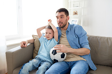 Image showing father and son watching soccer on tv at home