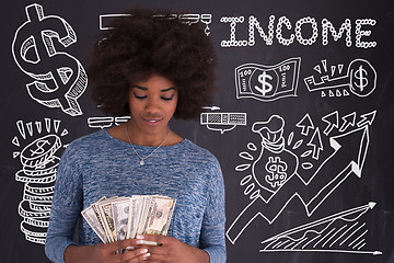 Image showing black woman holding money on gray background