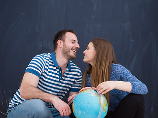 Image showing couple in casual clothing investigating globe