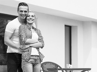 Image showing Happy two young lovers standing in front of modern house