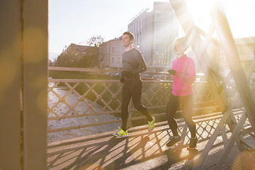Image showing healthy young couple jogging in the city