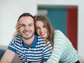 Image showing young handsome couple hugging on the sofa