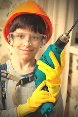 Image showing boy builder in goggles and with a drill