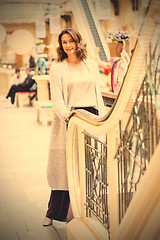 Image showing woman in a blue knitted coat near an escalator in a shopping cen