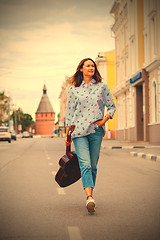 Image showing woman with a guitar smiles and goes along the road