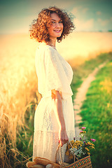 Image showing beautiful woman in a white dress with a basket with bread and mi