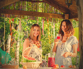 Image showing laughing women near a festive table with a wine glass in hands