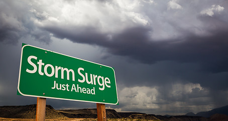 Image showing Storm Surge Just Ahead Green Road Sign and Stormy Clouds