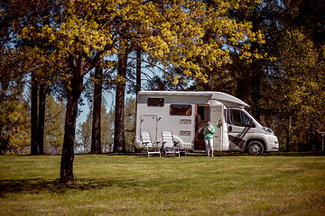 Image showing Woman is standing with a mug of coffee near the camper.