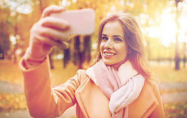 Image showing woman taking selfie by smartphone in autumn park