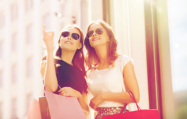 Image showing happy women with shopping bags outdoors