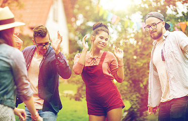 Image showing happy friends dancing at summer party in garden