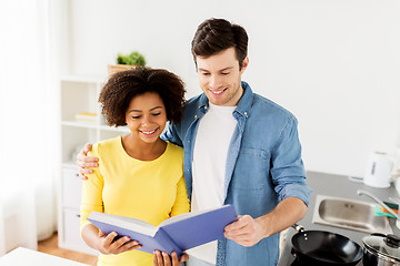 Image showing happy couple with cooking book at home kitchen