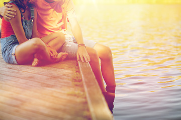 Image showing happy teenage couple sitting on river berth