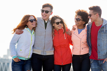 Image showing happy teenage friends in shades talking on street