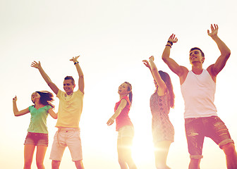 Image showing smiling friends dancing on summer beach