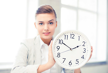 Image showing attractive businesswoman showing white clock