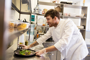Image showing happy male chef cooking food at restaurant kitchen