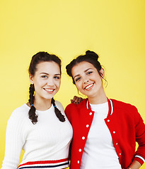 Image showing lifestyle people concept: two pretty young school teenage girls having fun happy smiling on yellow background 