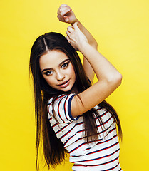 Image showing young pretty teenage woman angry posing on yellow background, fashion lifestyle people concept 