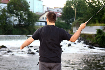 Image showing Young man with fishing rod fishing at a river in Bavaria