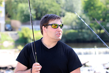 Image showing Young man with fishing rod fishing at a river in Bavaria