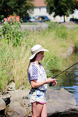 Image showing Woman with freckles and hot pants while fishing