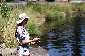 Image showing Woman with freckles and hot pants while fishing