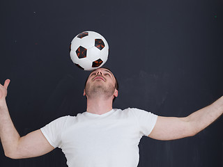 Image showing man playing with soccer ball isolated over grey